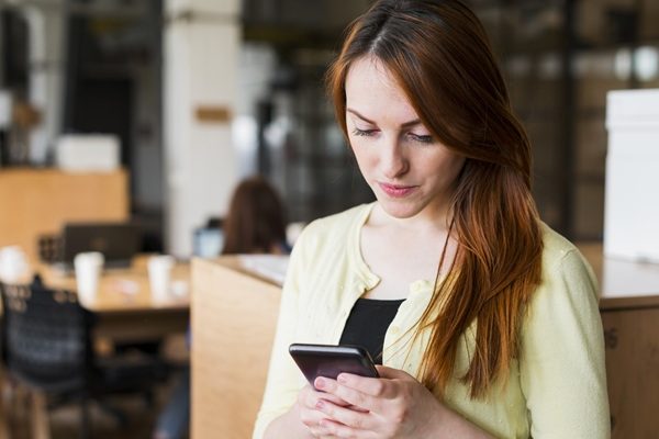Mujer revisando catálogo de productos para comprar por WhatsApp Business